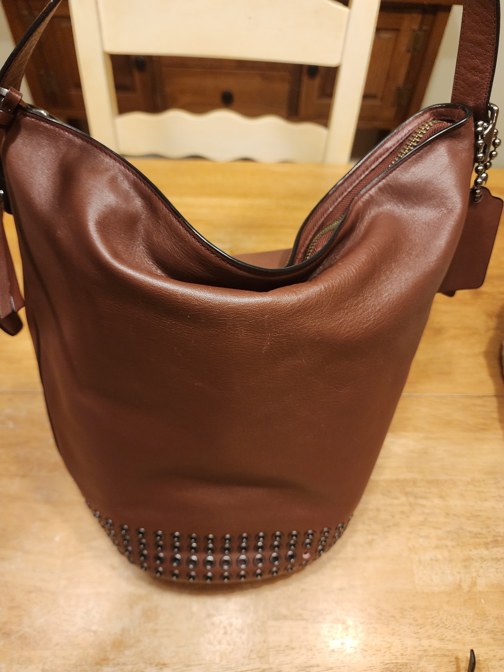 brown leather Coach Bleecker grommet duffle shoulder bag featuring  studded base